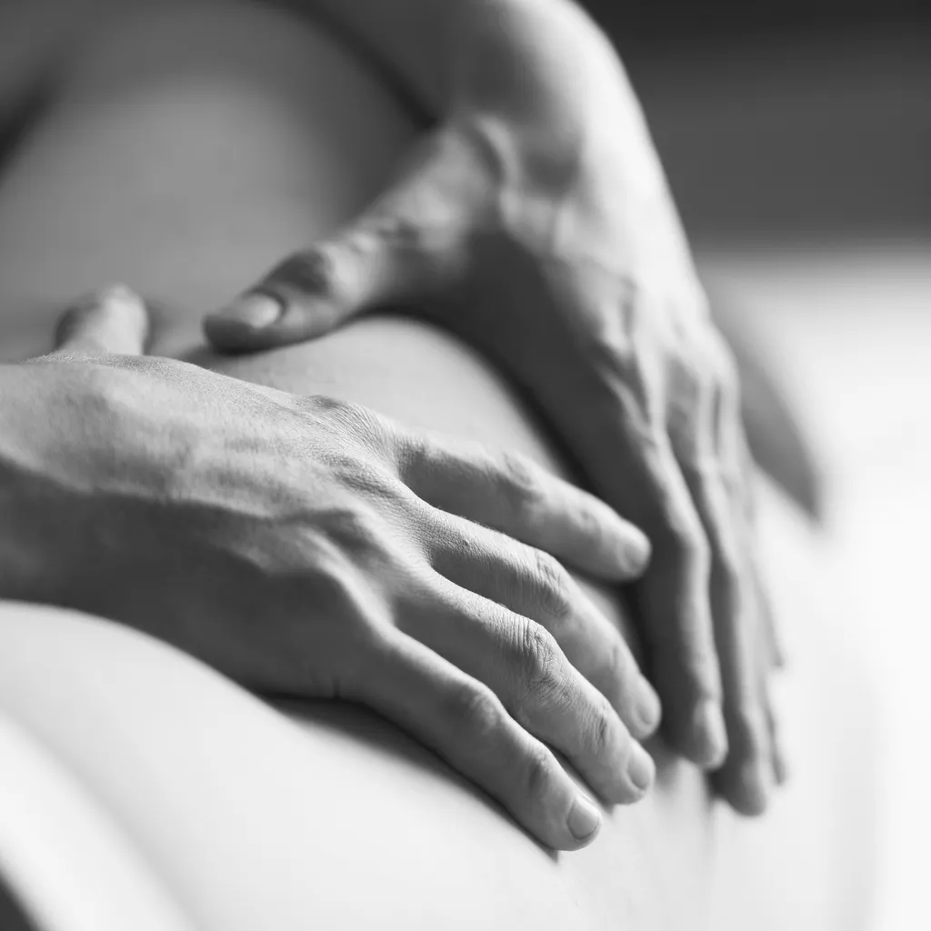 Mains d’ostéopathe posées sur le dos d’un patient